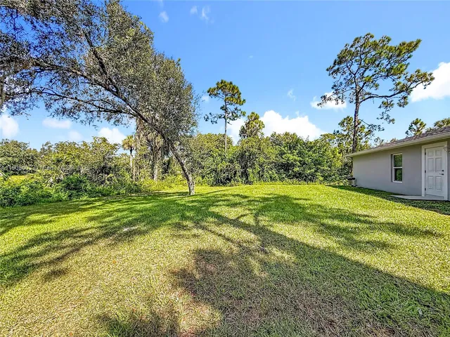a backyard of a house with lots of green space and fountain