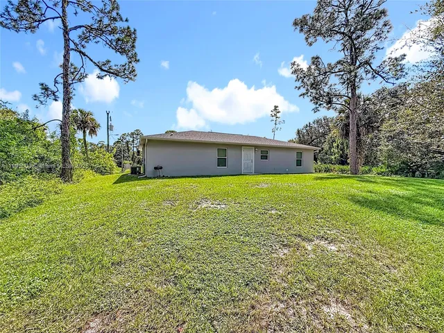 an aerial view of a house with a yard and lake view