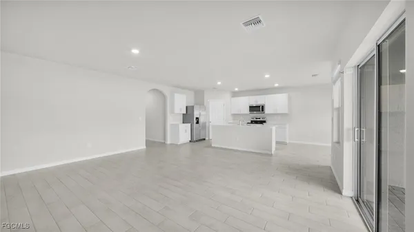 a view of a kitchen with a refrigerator and white cabinets