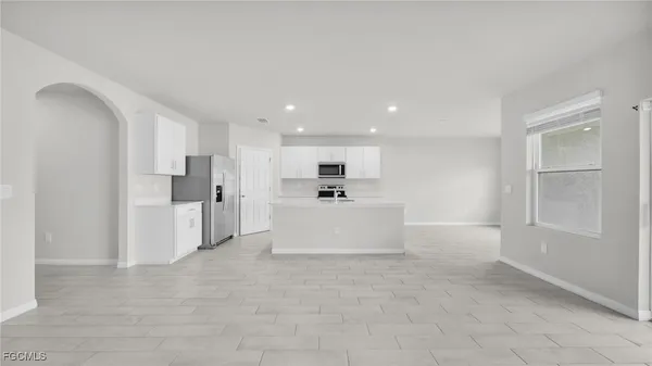 a large white kitchen with white cabinets and white stainless steel appliances