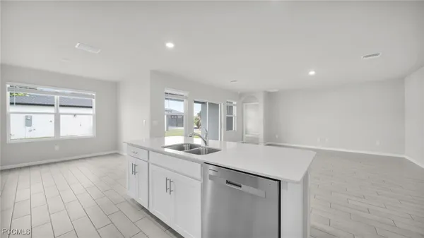 a hall with kitchen island white cabinets and a window