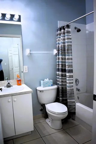 a white toilet sitting next to a bathroom sink and vanity