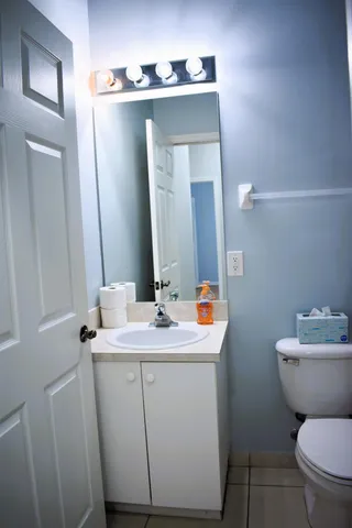 a bathroom with a toilet sink and mirror