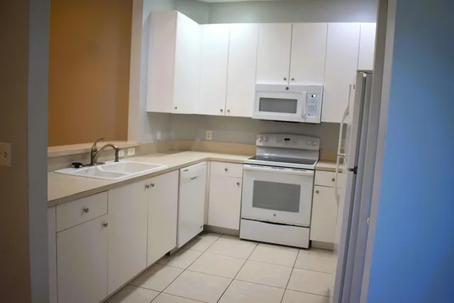 a kitchen with white cabinets and white appliances