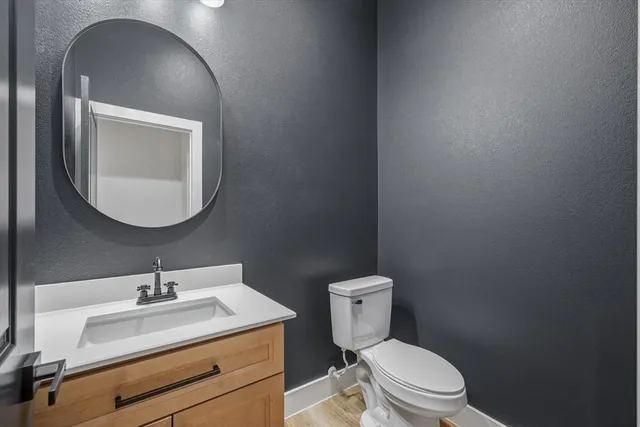 a bathroom with a toilet a sink and mirror