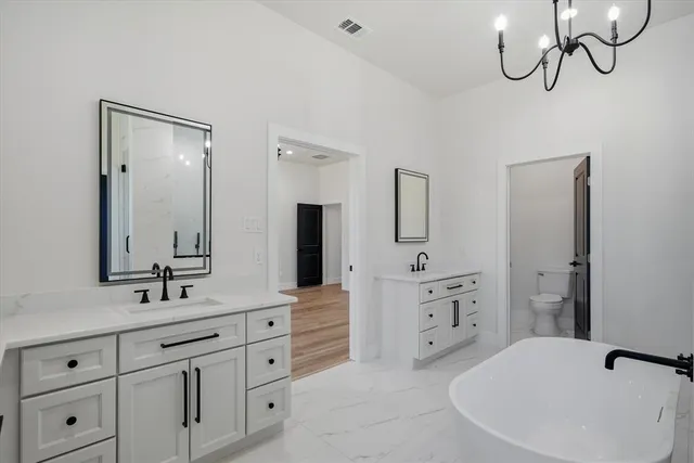 a bathroom with a granite countertop sink a toilet and shower