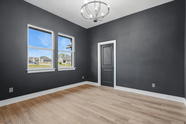an empty room with a window and wooden floor
