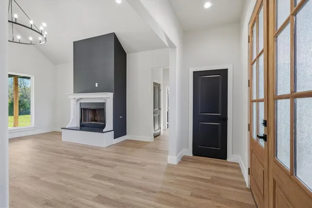 a view of an empty room with window and fireplace