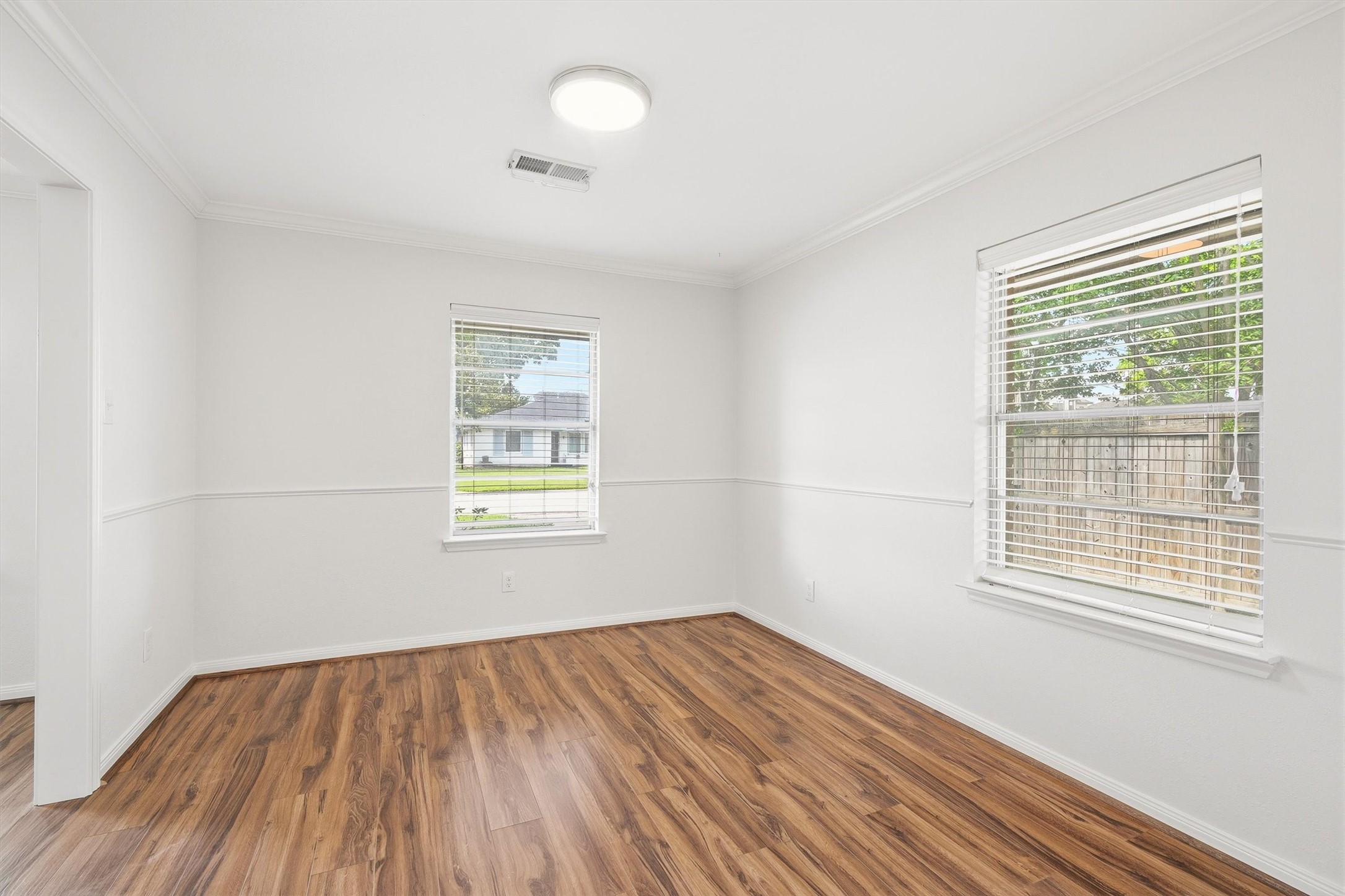 3331 Arbor Street Houston, TX 77004 - Photo 6 of 30 This bright room features large windows with blinds, allowing plenty of natural light. It has fresh white walls and attractive wood flooring, offering a clean and modern feel.
