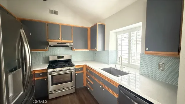 a kitchen with kitchen island a sink stove and refrigerator
