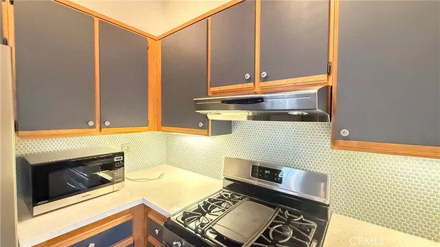 a kitchen with stainless steel appliances kitchen island granite countertop a stove a sink and a refrigerator