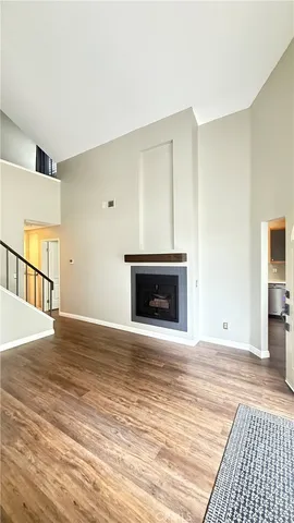 an empty room with wooden floor and fireplace