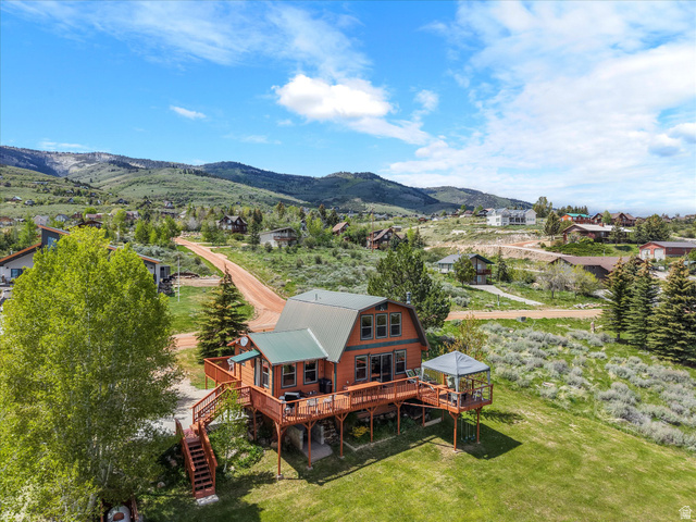 371 Lewis Loop, Unit 29 Fish Haven, ID 83287 - Photo 10 of 40 Hillside residence featuring a multi-level wooden deck, a covered outdoor structure, and a green metal roof