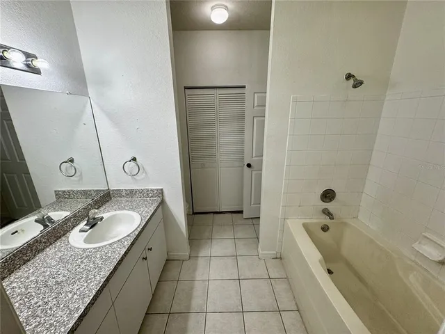 a bathroom with a granite countertop sink a mirror and shower