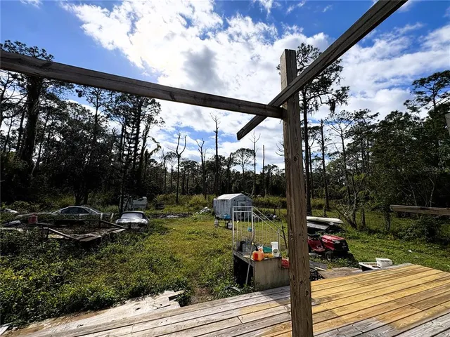 a view of yard from deck with patio
