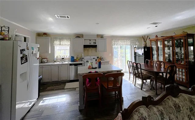 a kitchen with stainless steel appliances granite countertop a refrigerator and dining table
