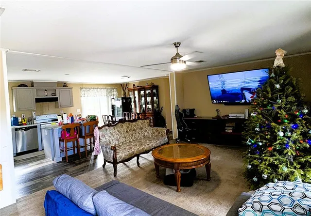 a living room with furniture and a dining table with wooden floor