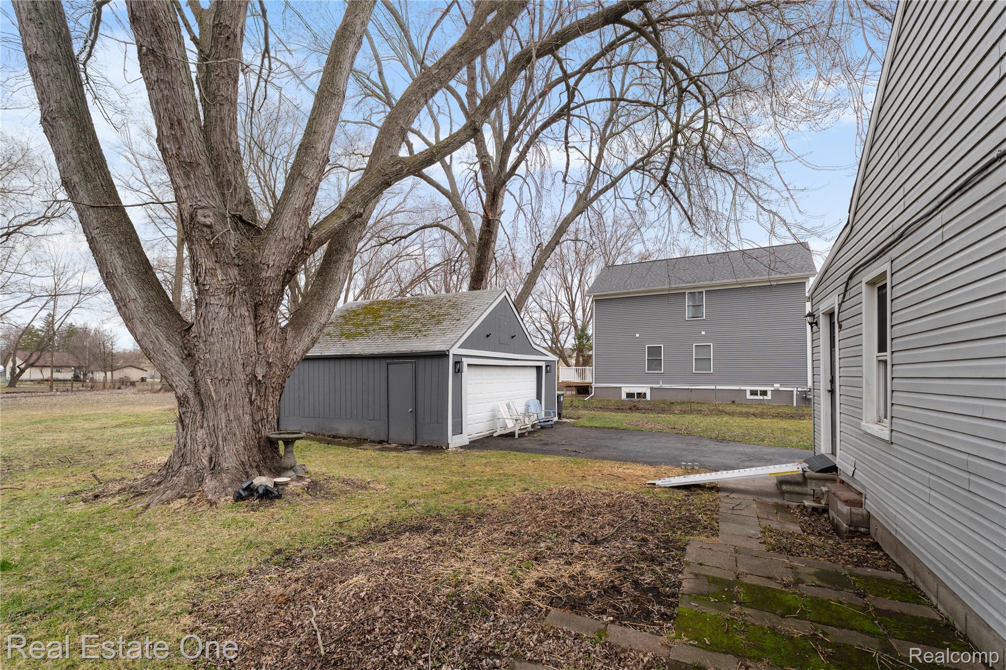 26170 Wick Road Taylor, MI 48180 - Photo 4 of 16 View of green lawn featuring an outbuilding and a garage