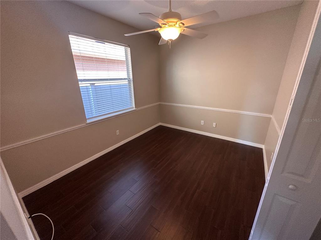 4962 Rock Rose Loop Sanford, FL 32771 - Photo 18 of 27 an empty room with wooden floor and windows