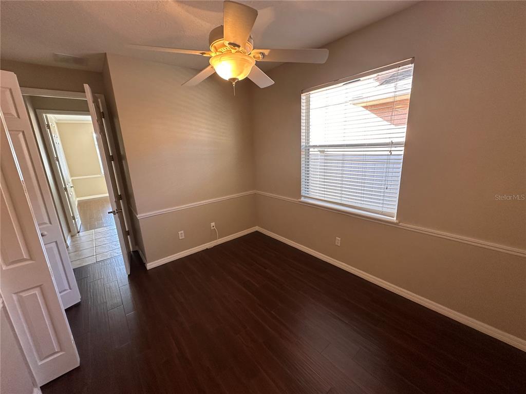 4962 Rock Rose Loop Sanford, FL 32771 - Photo 19 of 27 an empty room with wooden floor and windows