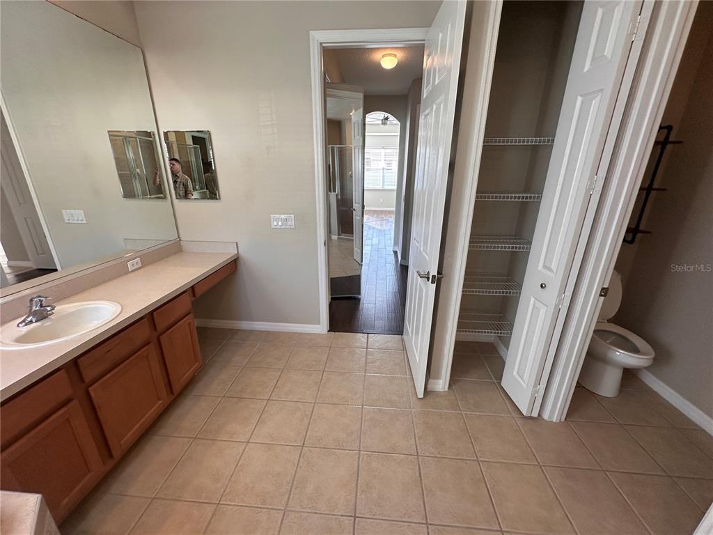 4962 Rock Rose Loop Sanford, FL 32771 - Photo 23 of 27 a bathroom with a sink a toilet and mirror