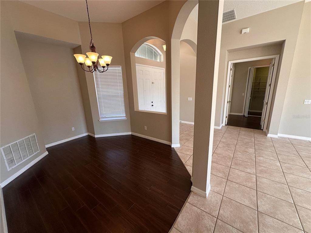 4962 Rock Rose Loop Sanford, FL 32771 - Photo 3 of 27 a view of a hallway with wooden floor and a chandelier