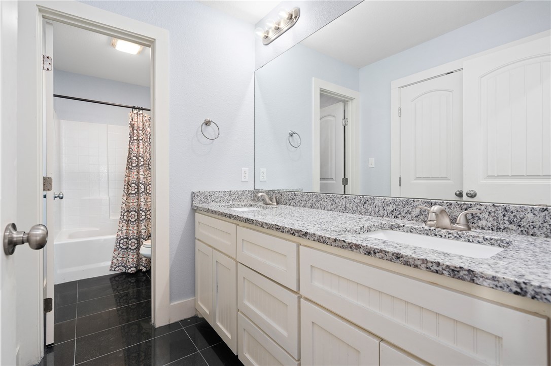 4331 Callicoatte Road Robstown, TX 78380 - Photo 24 of 40 a bathroom with a granite countertop sink a mirror and a shower