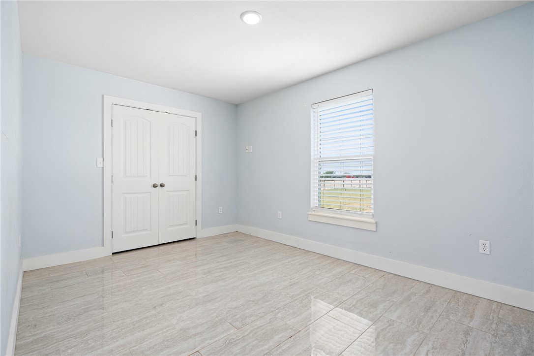 4331 Callicoatte Road Robstown, TX 78380 - Photo 26 of 40 an empty room with wooden floor and windows