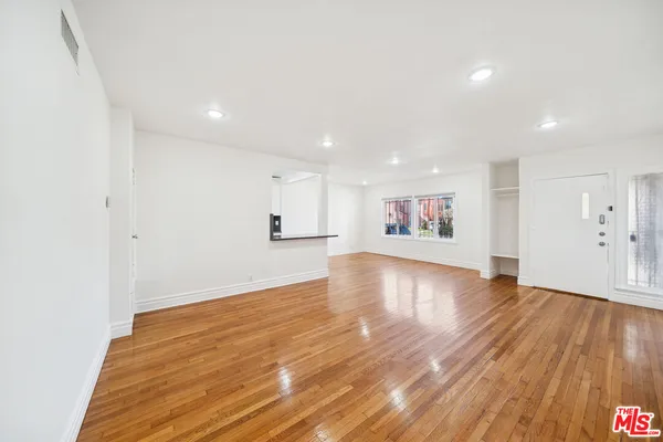 a view of an empty room with wooden floor