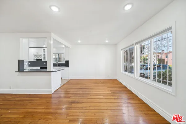 a view of a kitchen with kitchen island a sink wooden floor and a counter top space