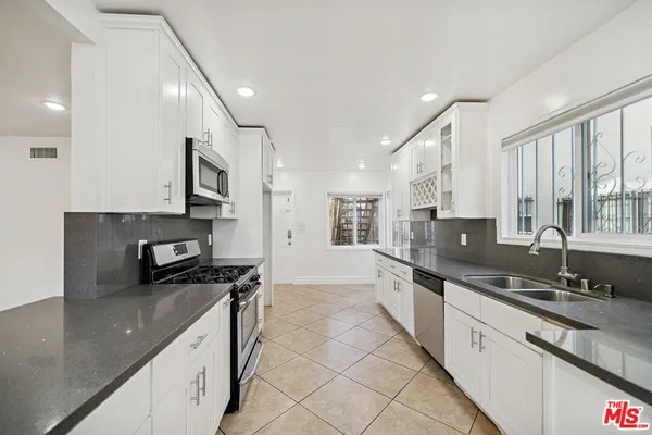 a large kitchen with stainless steel appliances lots of counter space and a sink