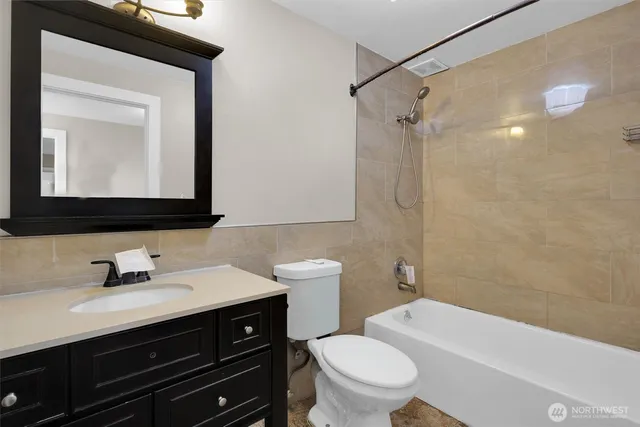 a bathroom with a sink a toilet a mirror and shower