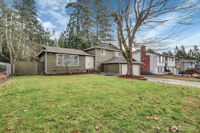 a view of a house with backyard and a tree
