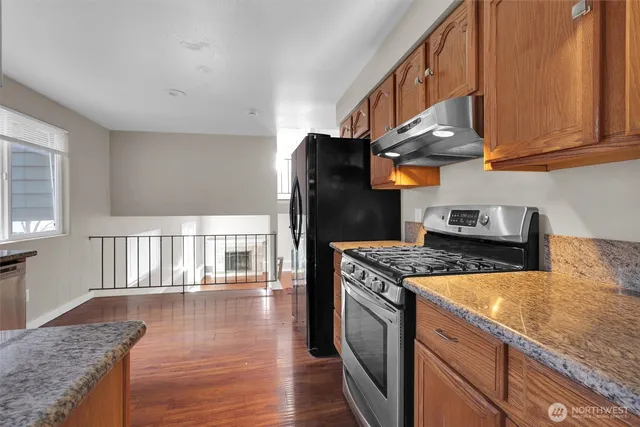 a kitchen with stainless steel appliances granite countertop a stove a refrigerator and a cabinets