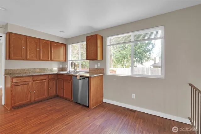 a kitchen with granite countertop wooden floors and white appliances