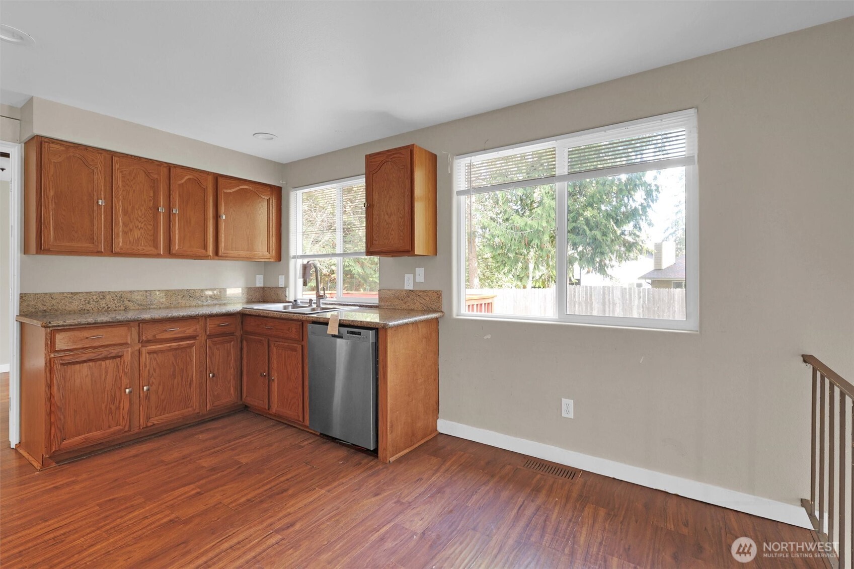 18518 131st Avenue Southeast Renton, WA 98058 - Photo 9 of 34 a kitchen with granite countertop wooden floors and white appliances