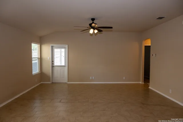 an empty room with windows and fan
