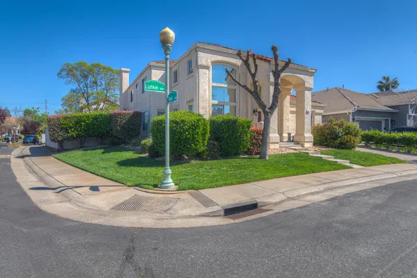 a view of a big building with a big yard and plants