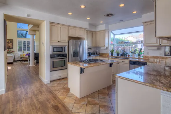 a kitchen with stainless steel appliances granite countertop a stove and cabinets
