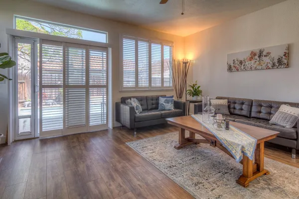 a view of a hallway with wooden floor and windows