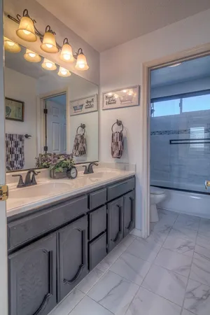 a bedroom with a bed a dresser and wooden floor