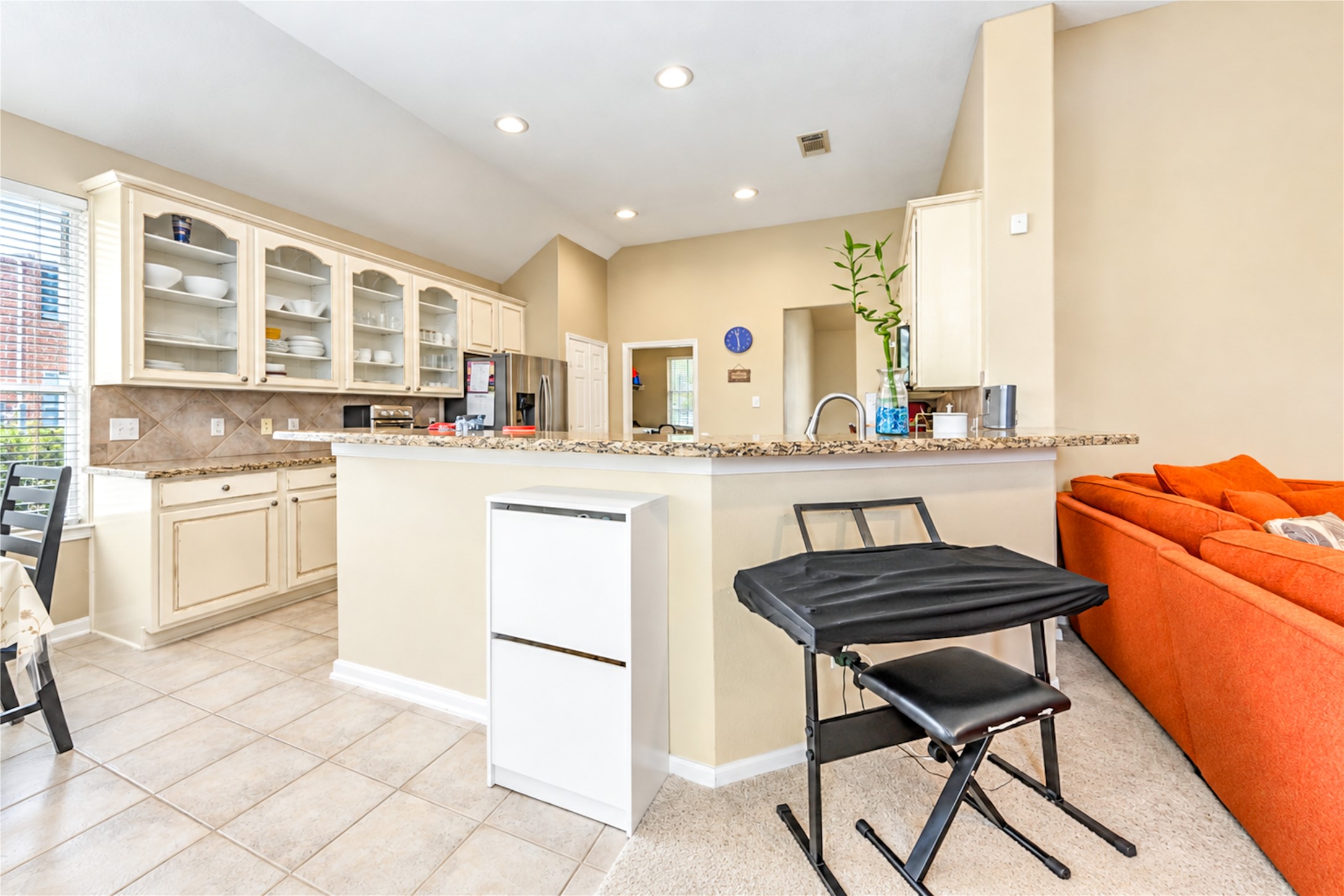 12806 Ridge Bank Lane Houston, TX 77041 - Photo 14 of 44 Bright and spacious kitchen with granite countertops, stainless steel appliances, and ample cabinetry, seamlessly connected to a cozy living area.
