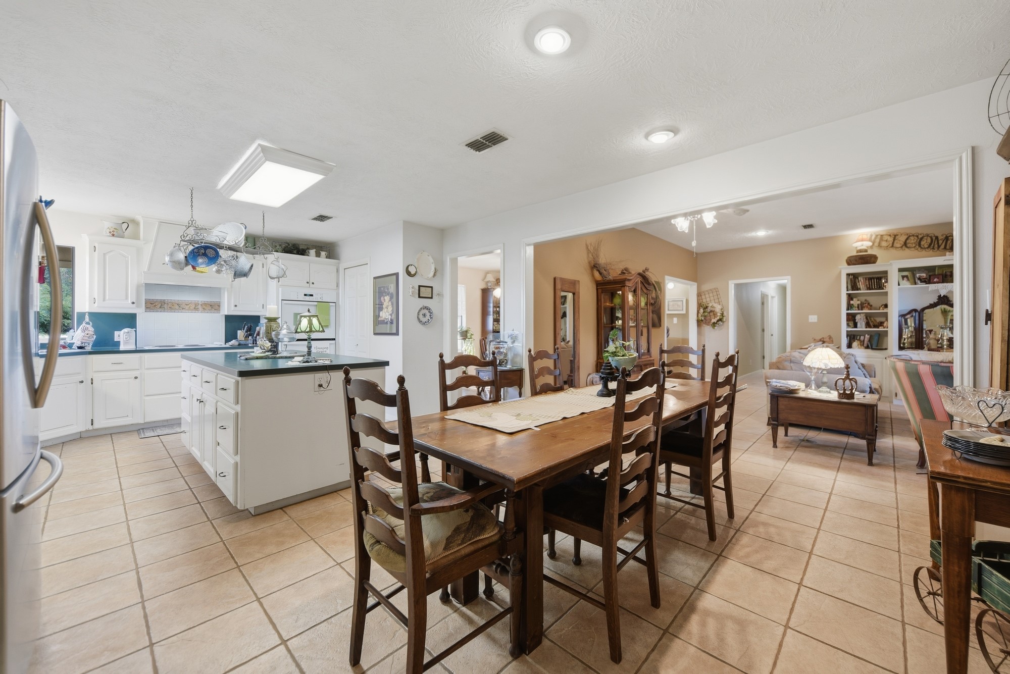 6950 Old Mill Creek Road Brenham, TX 77833 - Photo 19 of 40 a kitchen with stainless steel appliances kitchen island granite countertop a stove a sink a dining table and chairs