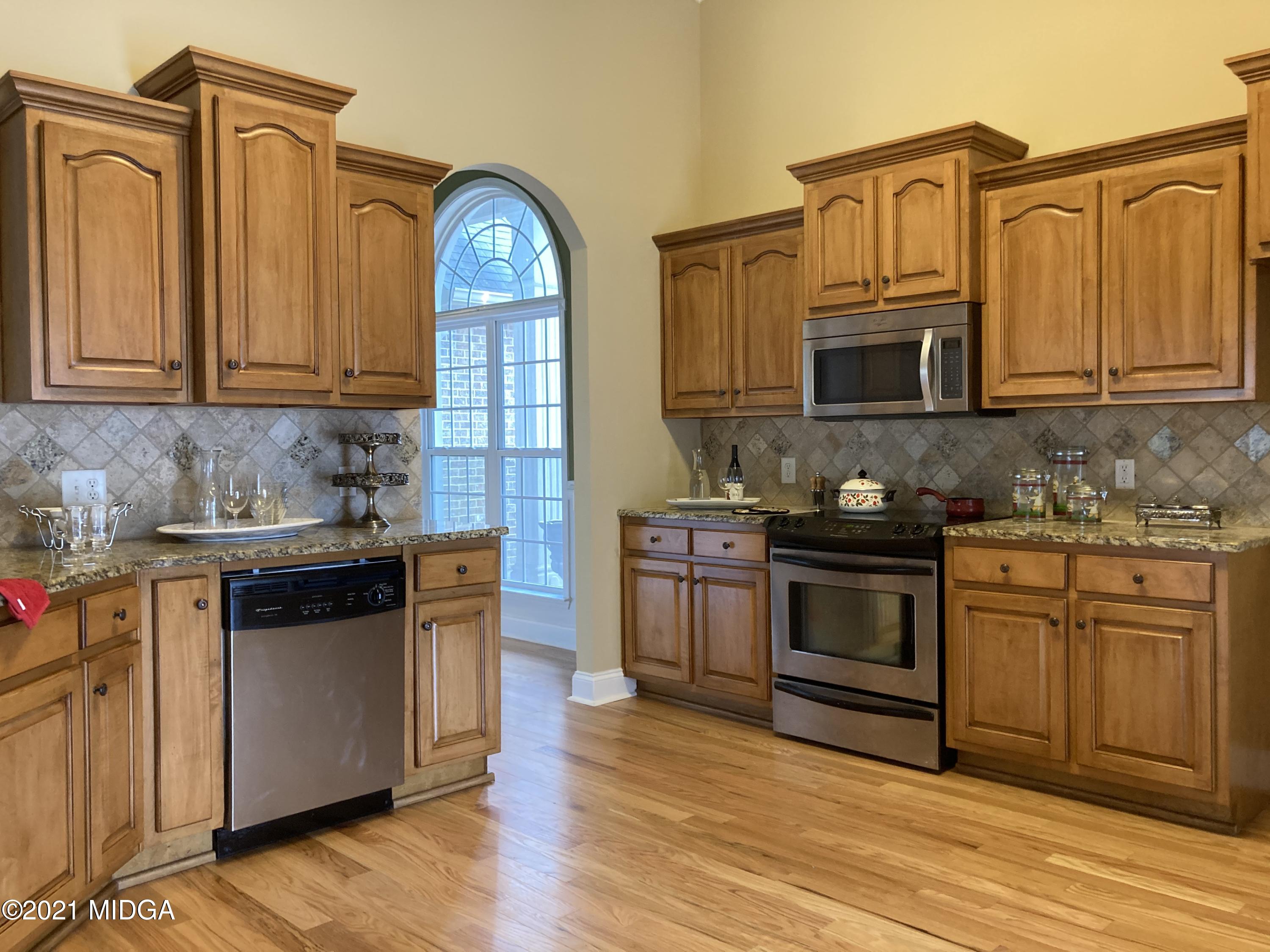 3640 Jones Road Macon, GA 31216 - Photo 8 of 39 a kitchen with stainless steel appliances granite countertop a stove a sink dishwasher and a microwave oven with wooden cabinets
