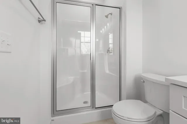 a white toilet next to a bathroom
