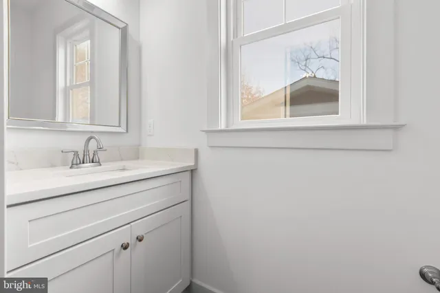 a bathroom with a sink vanity and mirror