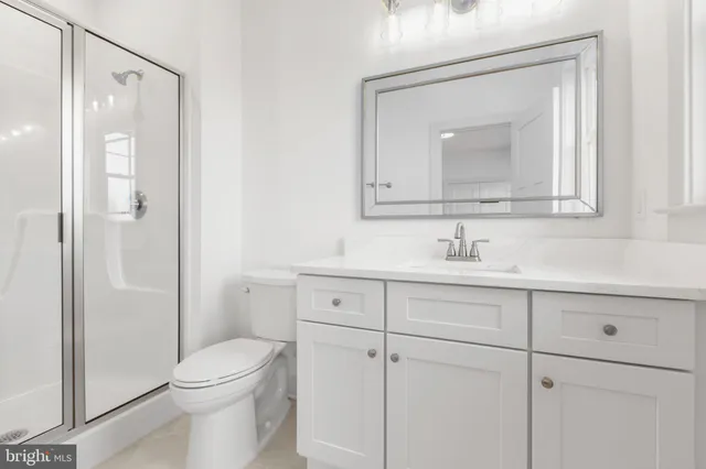 a bathroom with a toilet a sink a vanity and mirror