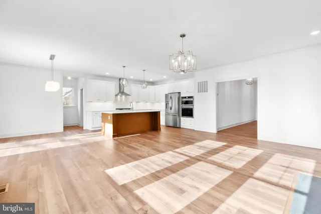 a view of a kitchen with a sink stainless steel appliances furniture and a kitchen view