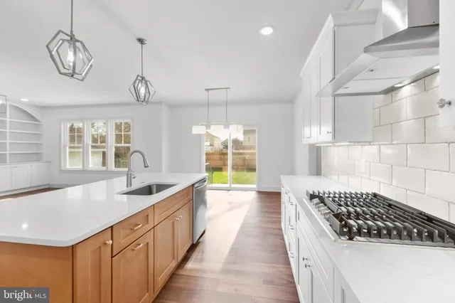 a kitchen with stainless steel appliances a sink and a wooden floors