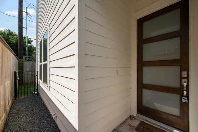 a view of an empty room with a kitchen and windows